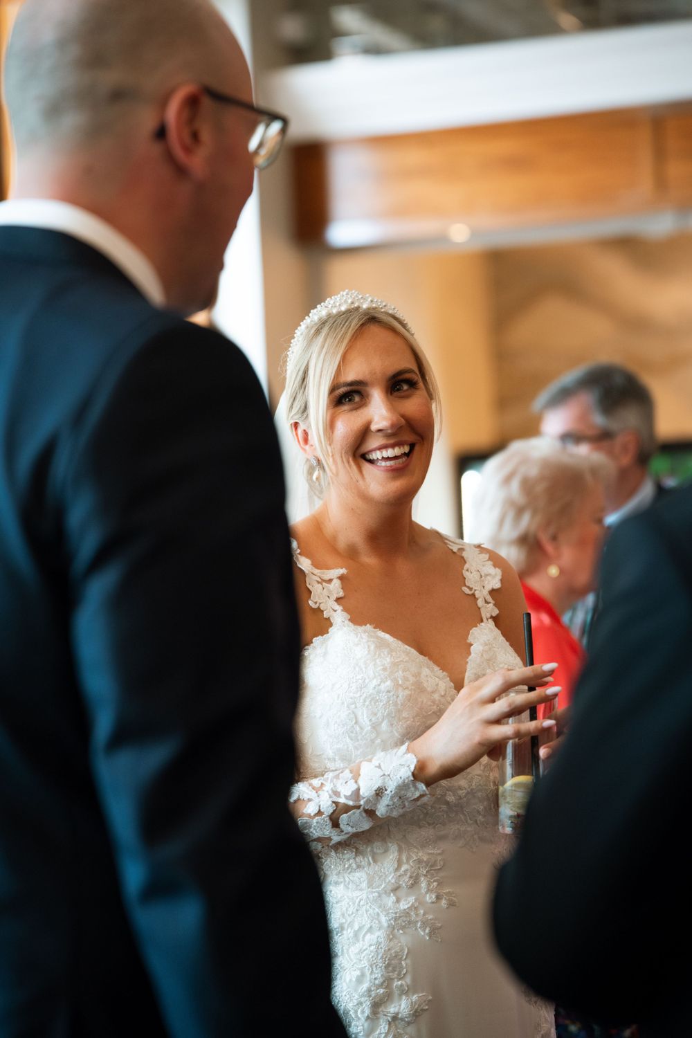 Wedding reception guests socializing in a warm, wood-paneled venue.