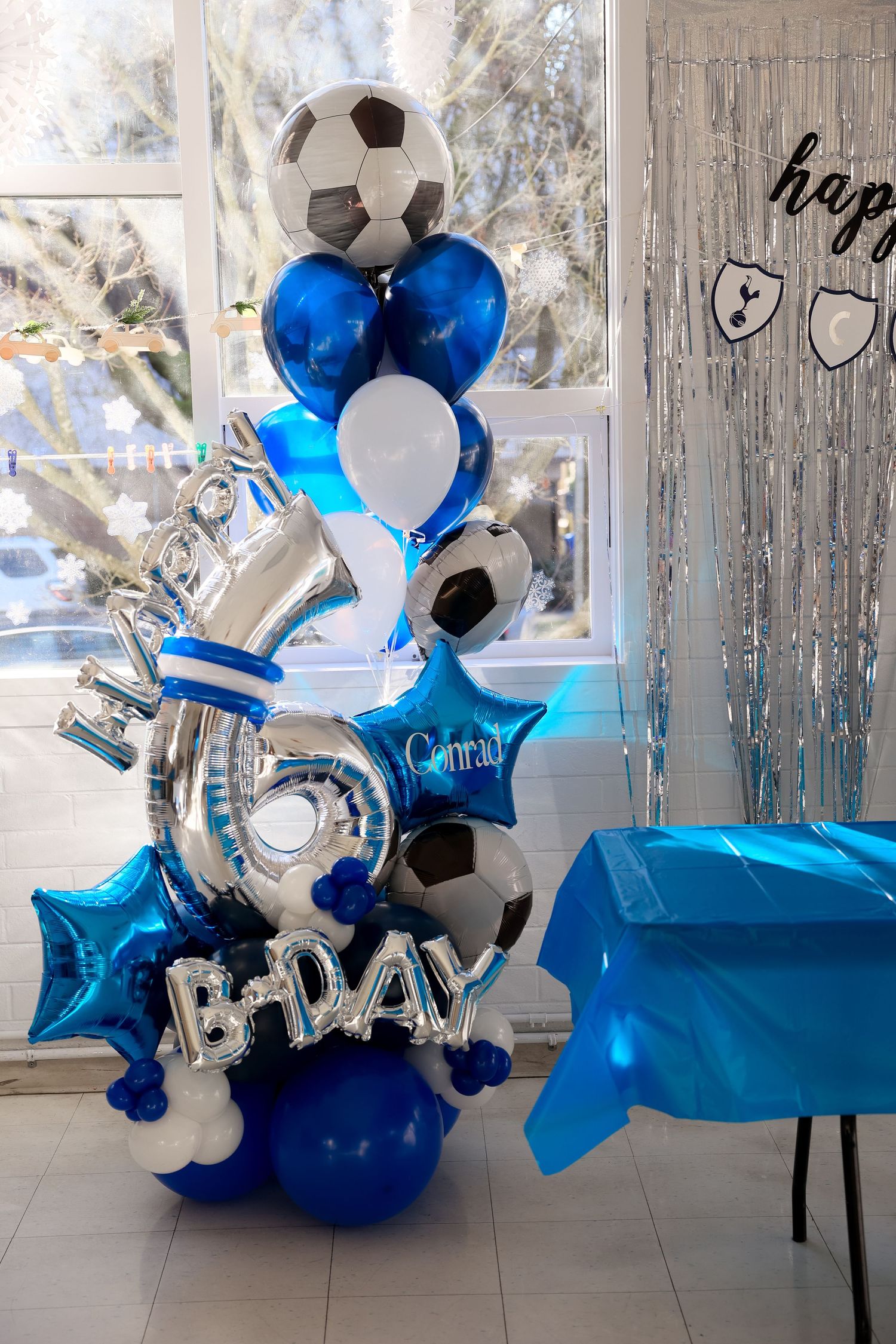Blue and white balloon display featuring soccer ball-shaped balloons.Event and Birthday Photography by Smilein.
