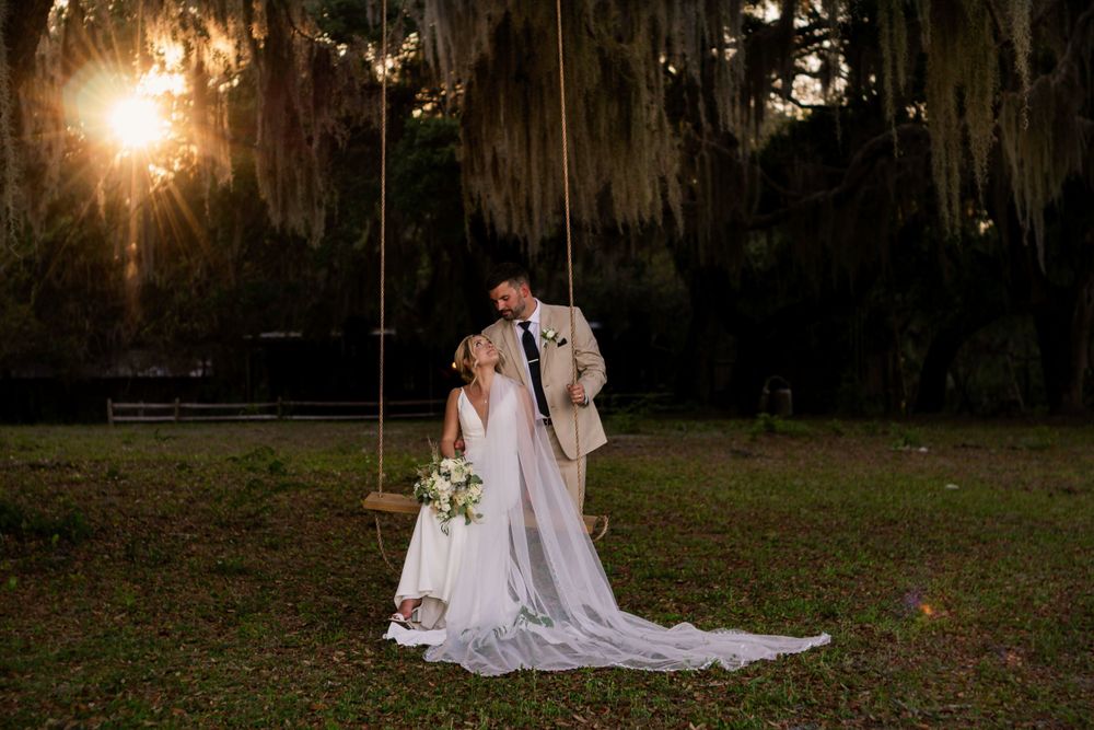 Sunset wedding portrait with Spanish moss and long flowing dress in golden light.