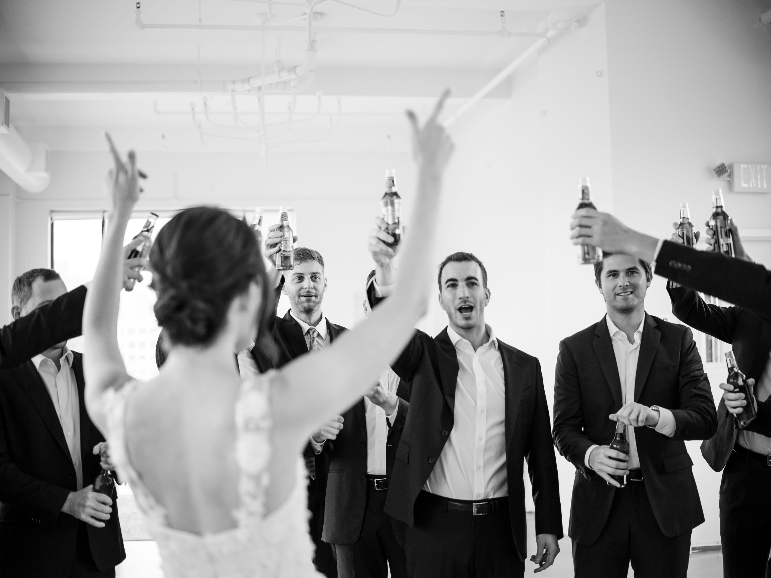 Wedding guests celebrate joyfully in black and white during reception festivities.