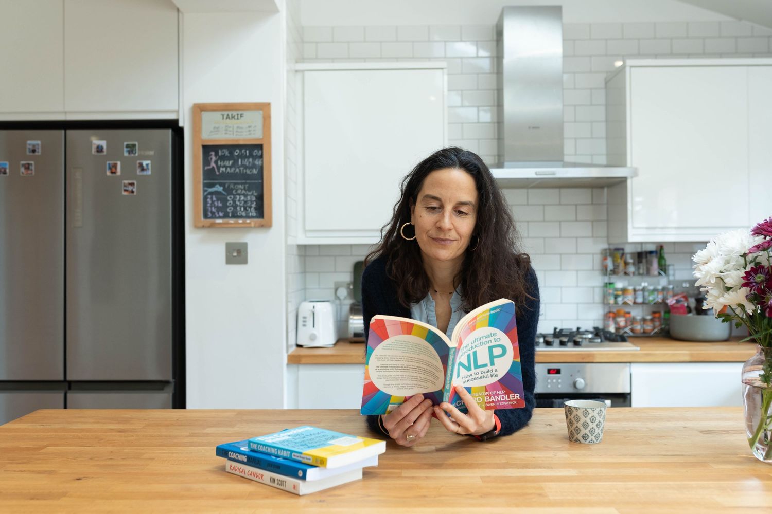 confidence coach reads book in the kitchen on personal branding shoot in brighton