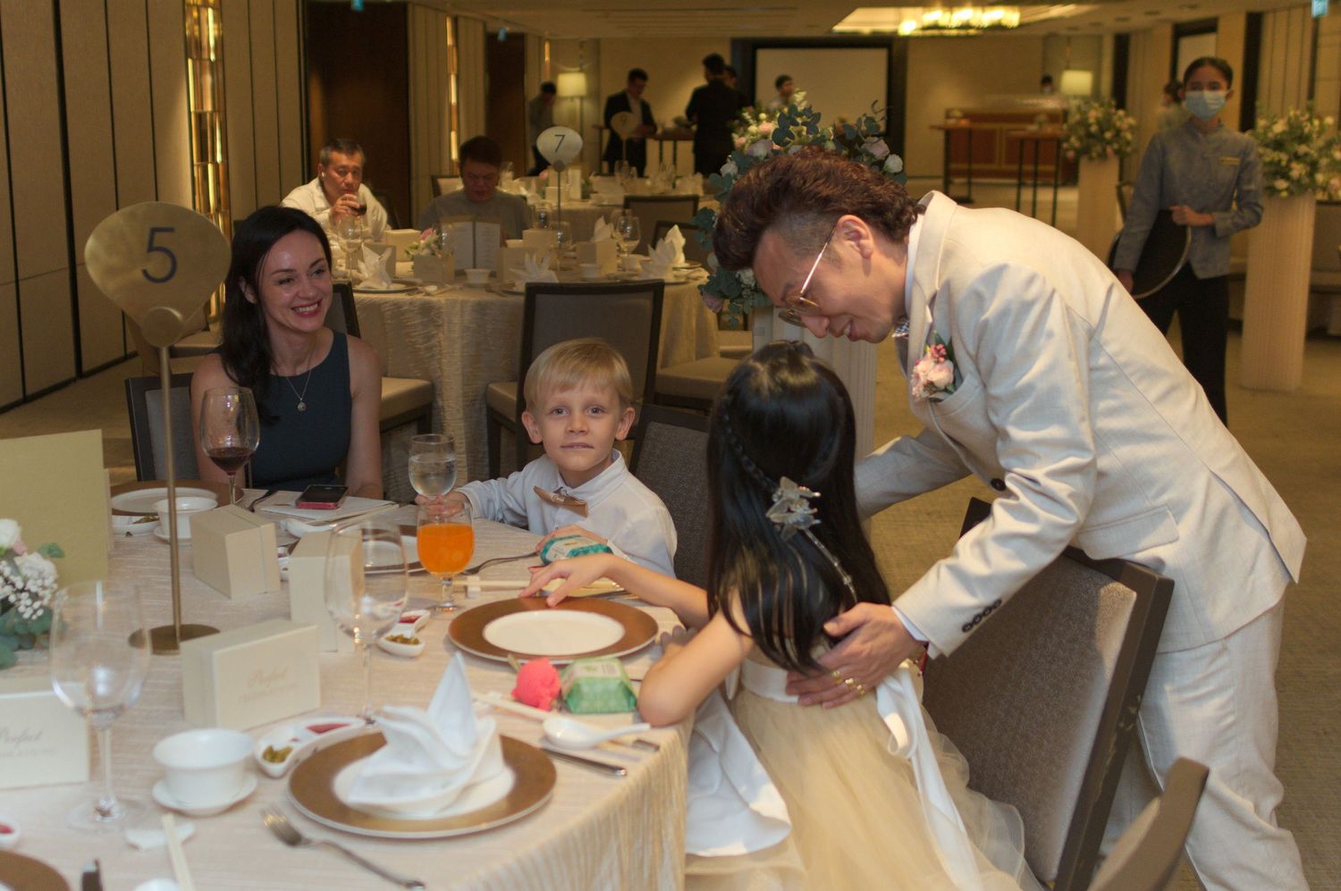 Restaurant dining scene with people gathered around a table being served.