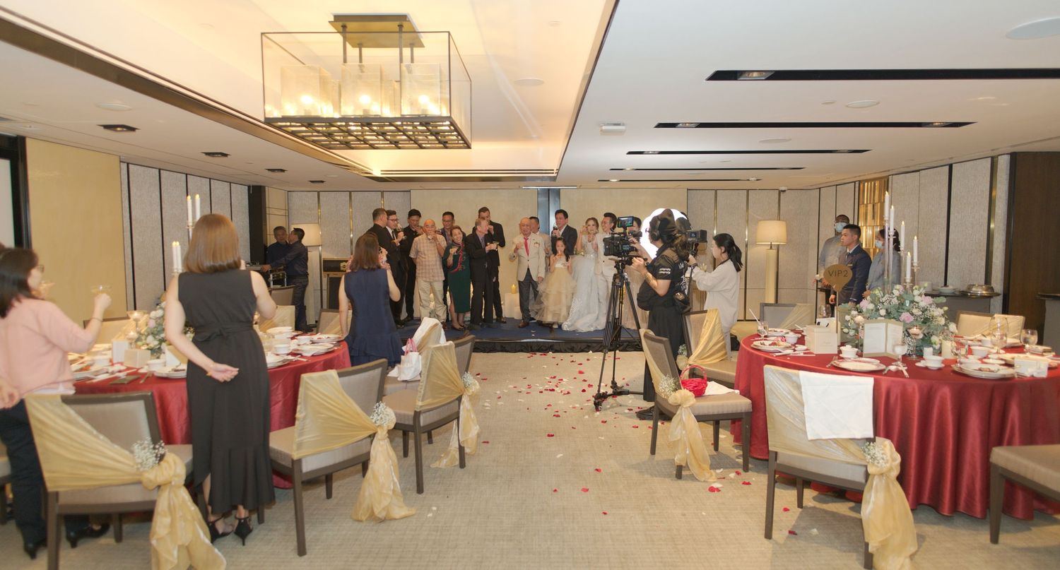 Wedding reception venue with tables decorated in red linens and elegant place settings.