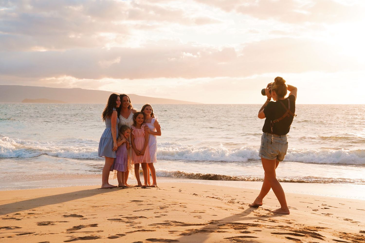 Silhouettes of professional photographer taking photos on a beach at sunset.