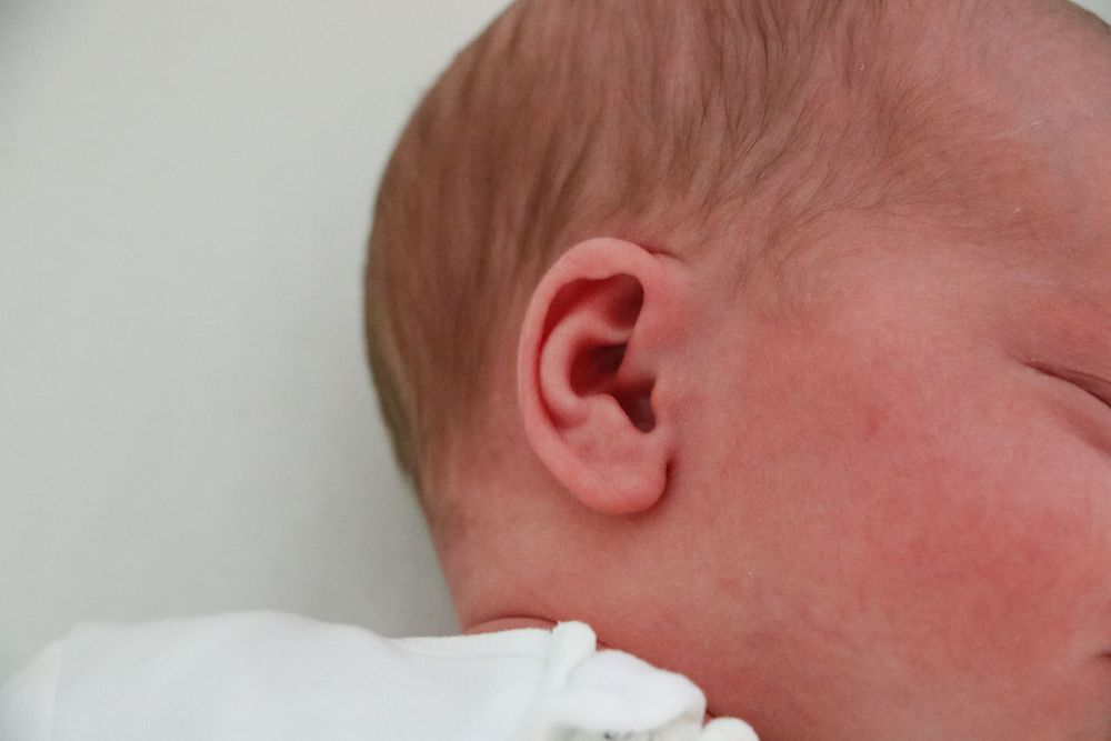 Close-up detail of newborn baby's ear and skin texture.