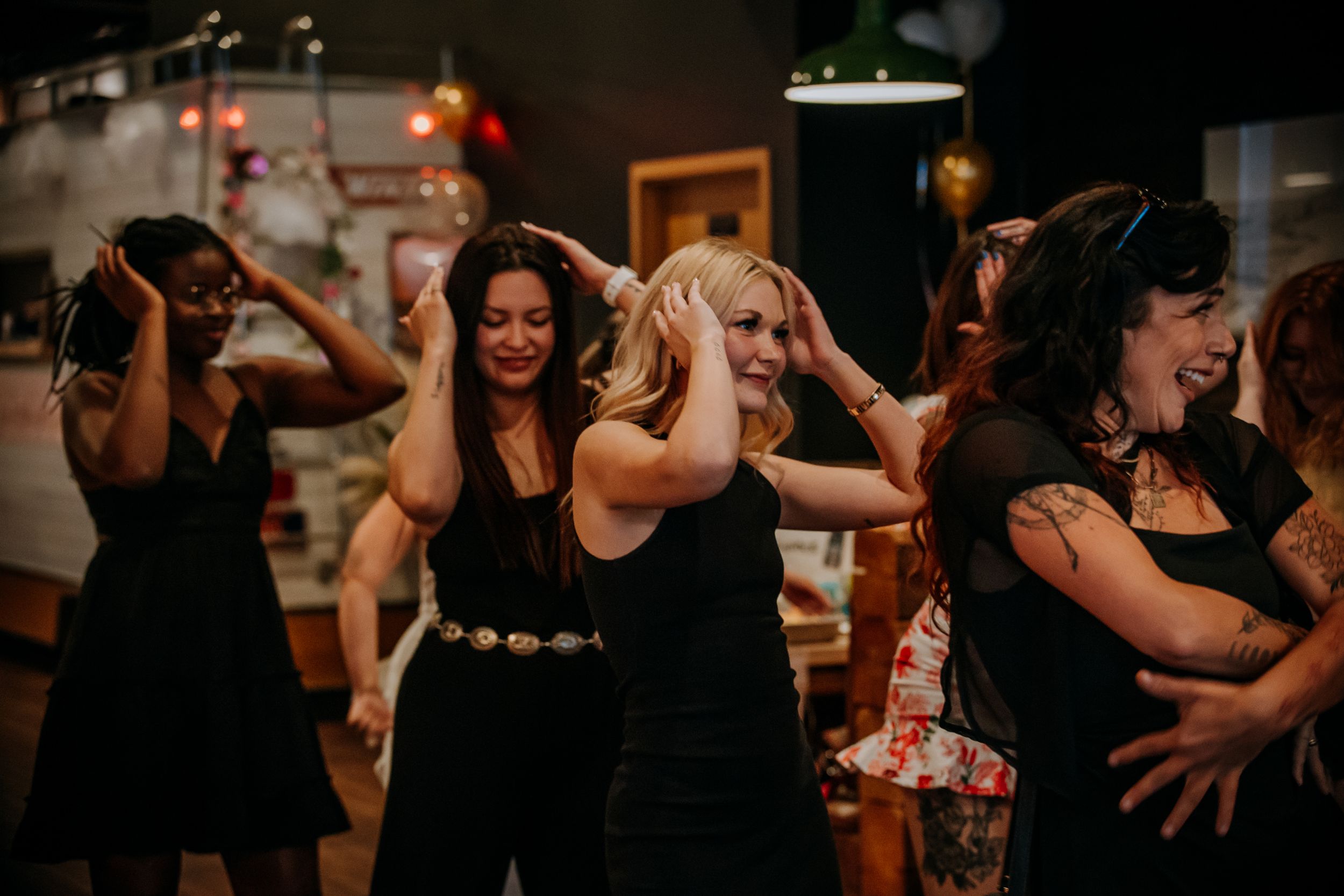 Group of dancers moving in sync during a social dance gathering in a dark indoor venue.
