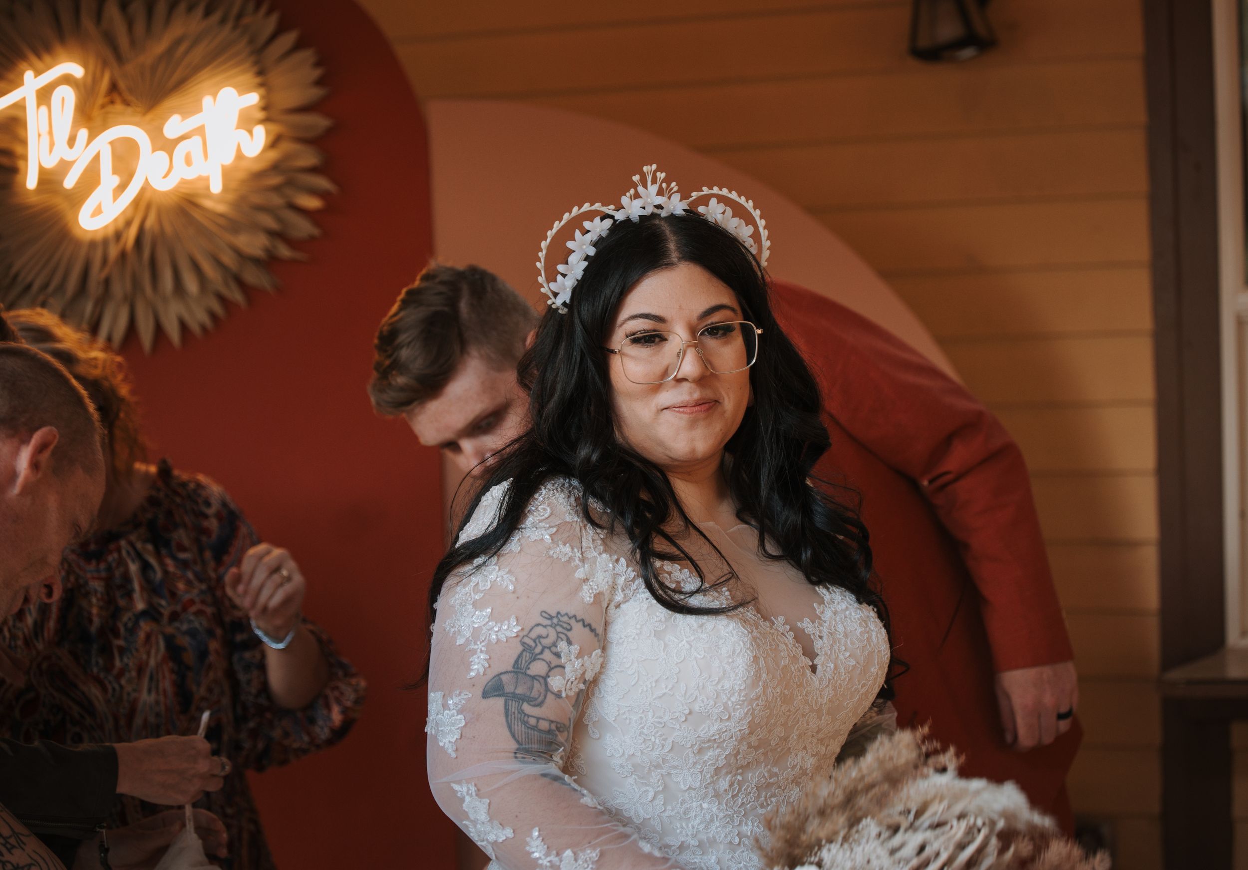 A joyful celebration scene with a bride in a lace gown wearing a sparkling tiara.