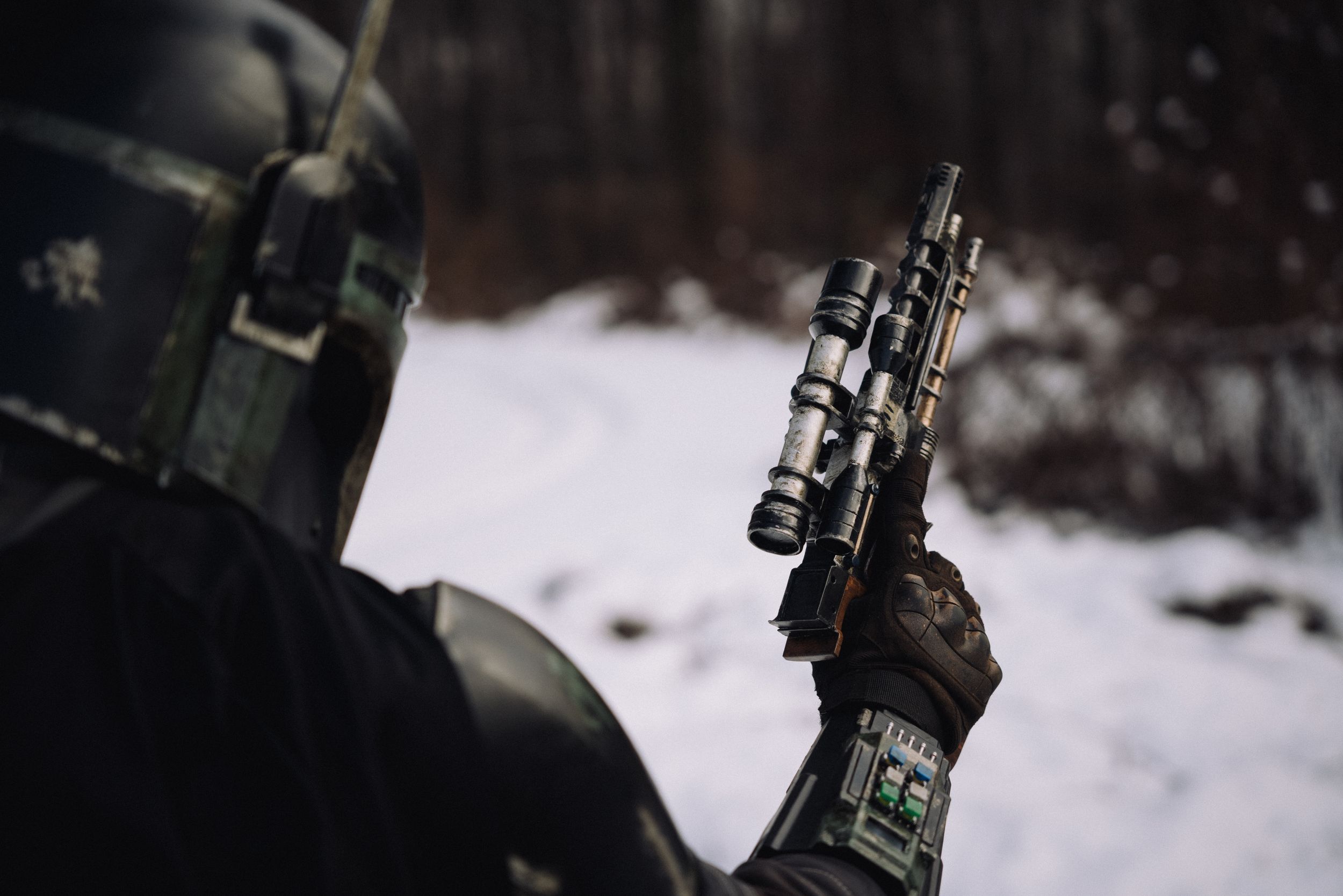 Mandalorian cosplay featuring a detailed costume with a gun in focus, showcasing intricate armor and accessories.