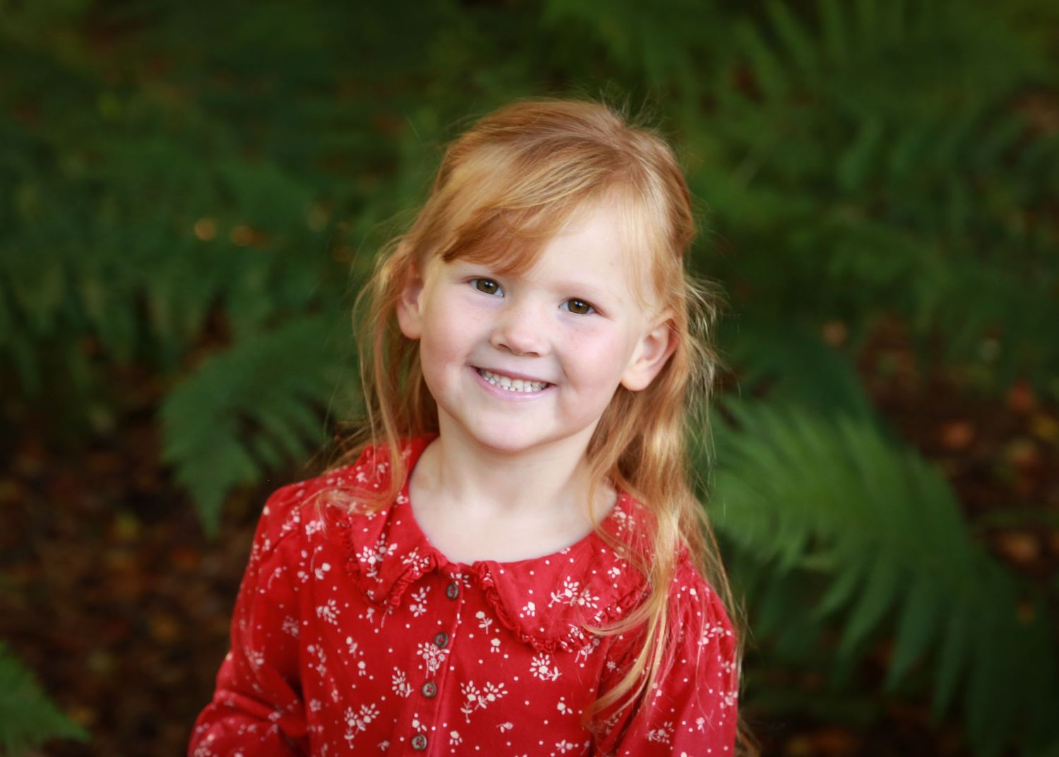A joyful little girl with vibrant red hair exploring the peaceful woods, her playful spirit and connection with nature at photo session