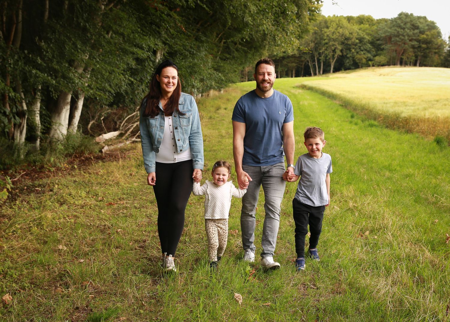 A joyful family enjoying a moment together in the tranquil surroundings of Dunnottar Woods, capturing the beauty of nature and connection