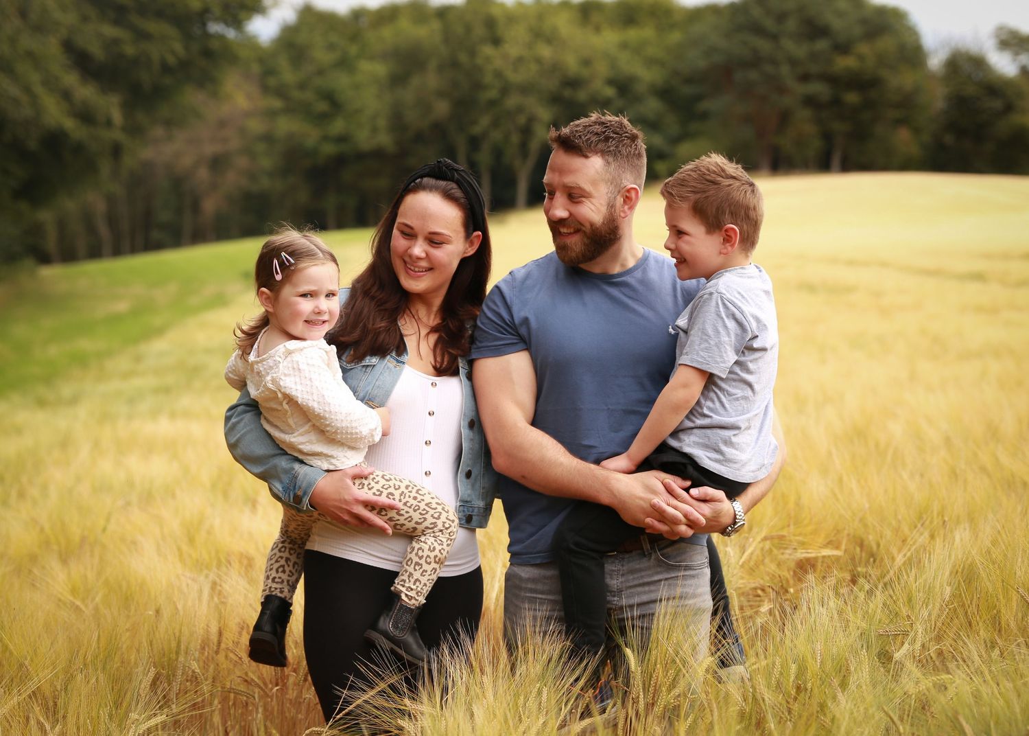 A joyful family enjoying a moment together in the tranquil surroundings of Dunnottar Woods, capturing the beauty of nature and connection