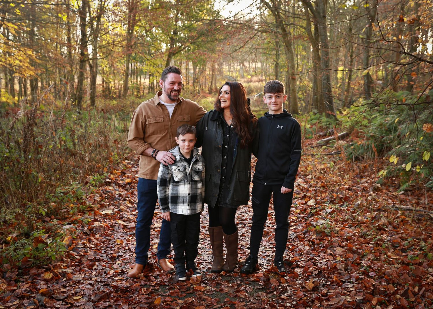 A joyful family enjoying a moment together in the tranquil surroundings of Dunnottar Woods, capturing the beauty of nature and connection
