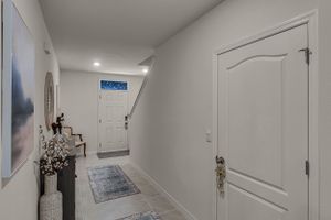 White hallway interior with modern doors and lighting fixtures.