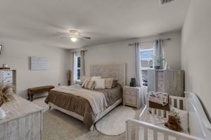 Cozy bedroom featuring neutral bedding, white furniture, and decorative wall art.