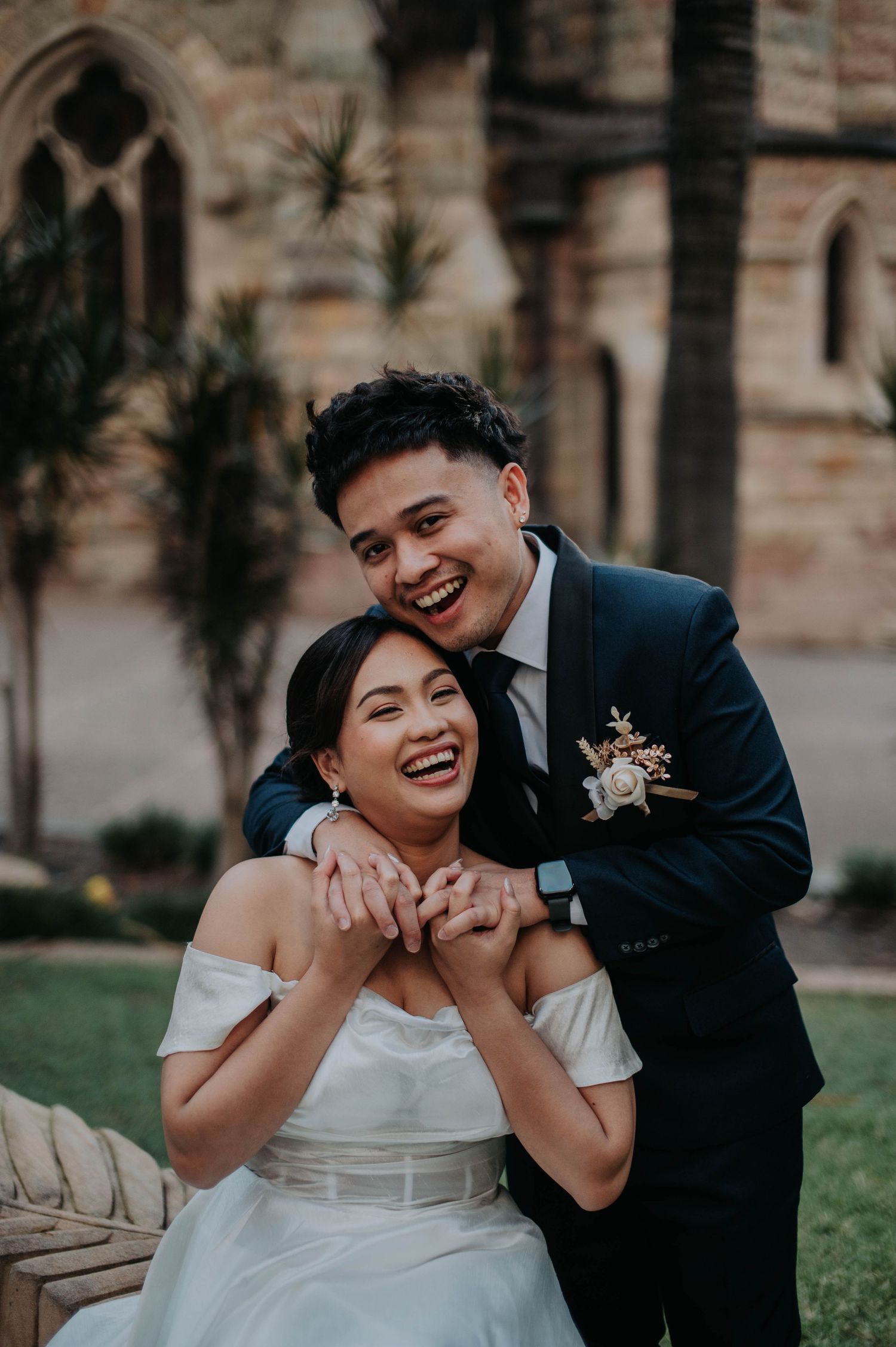 A joyful couple shares a candid laughing moment during their wedding photoshoot.