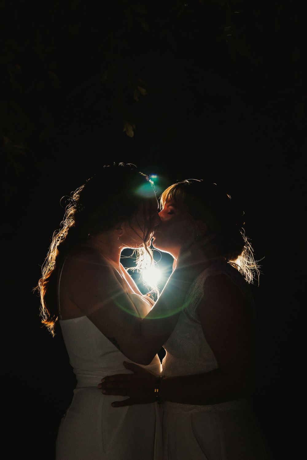 Dramatic nighttime wedding portrait with sparklers creating light trails.