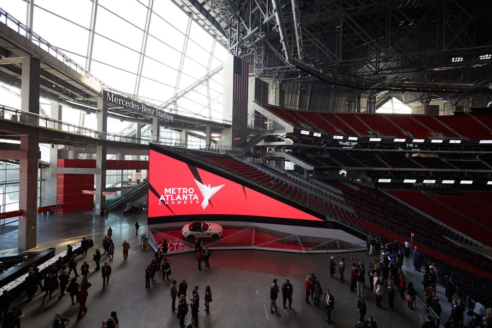 Fan gathering area inside Mercedes-Benz Stadium with red angular architectural features.
