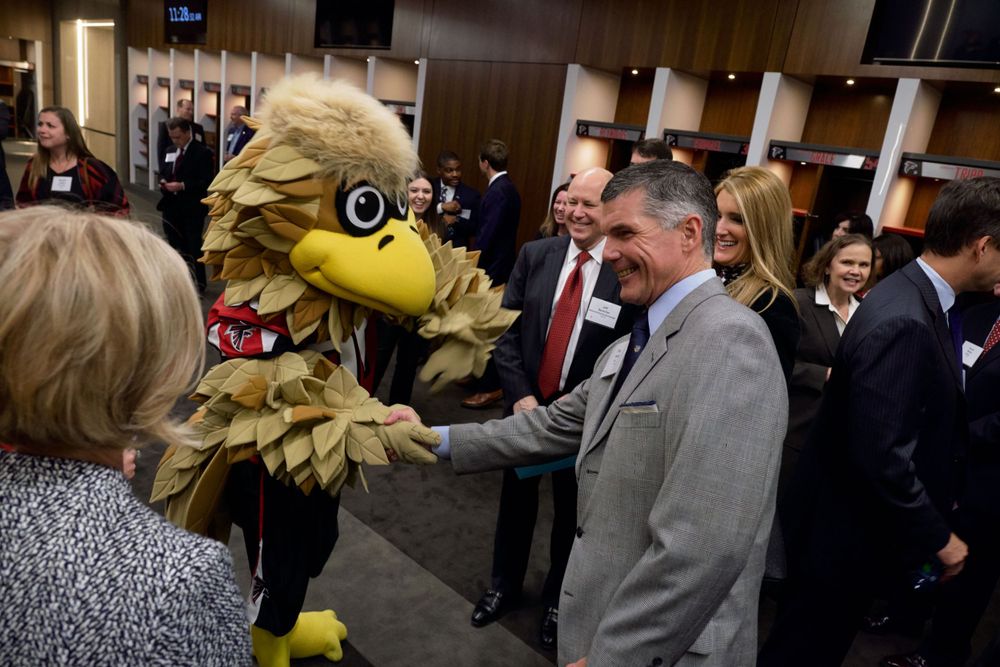 Team mascot interacting with attendees at stadium event.