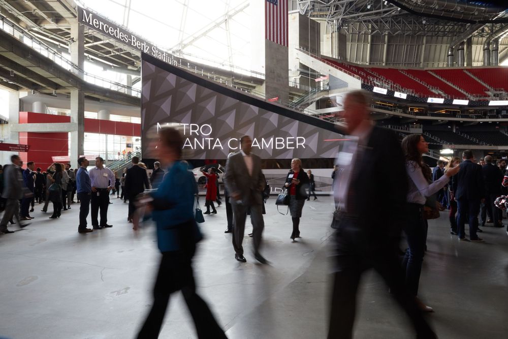 Blurred motion of people walking through stadium concourse.