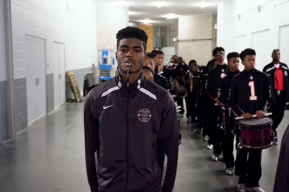 Group of athletes lined up in stadium hallway wearing team uniforms.