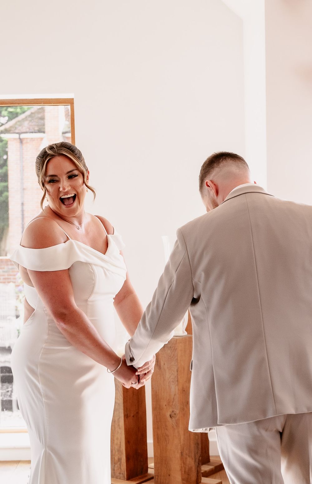 A series of candid wedding moments showing a couple in white attire sharing joyful interactions in a bright indoor setting.