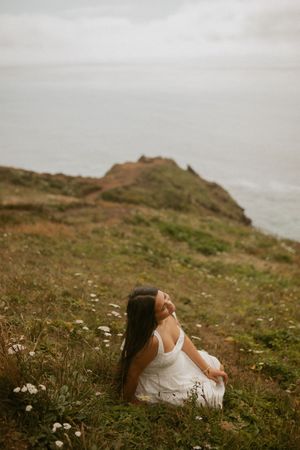 Ethereal coastal scene with wildflowers on a grassy clifftop overlooking the misty ocean.