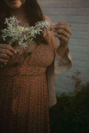 a woman holding and touching a bouquet of small white flowers