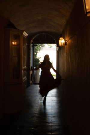 woman walking down a dimly lit hallways looking into the camera