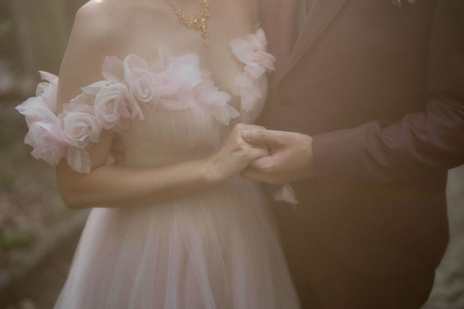 Delicate detail shot of floral embellishments on wedding dress in soft light.