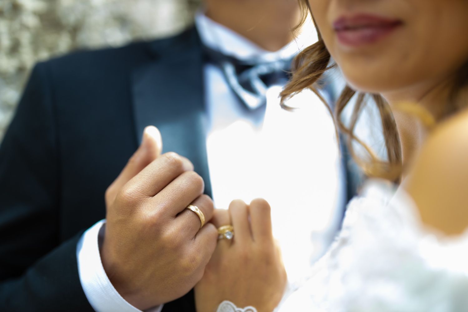 Close-up shot of wedding rings and formal attire details.