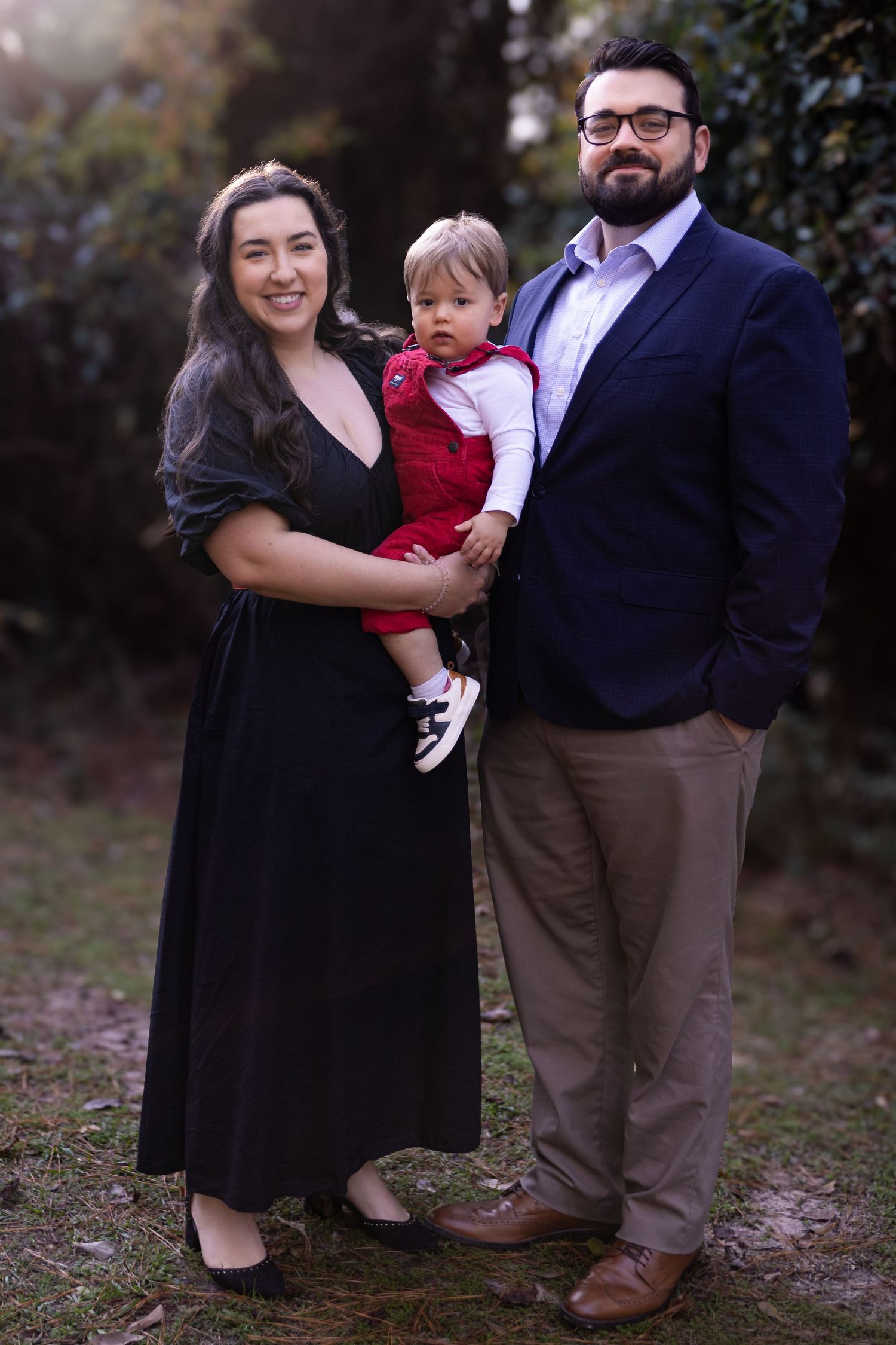 Family portrait session in casual attire captured during golden hour in a natural outdoor setting.