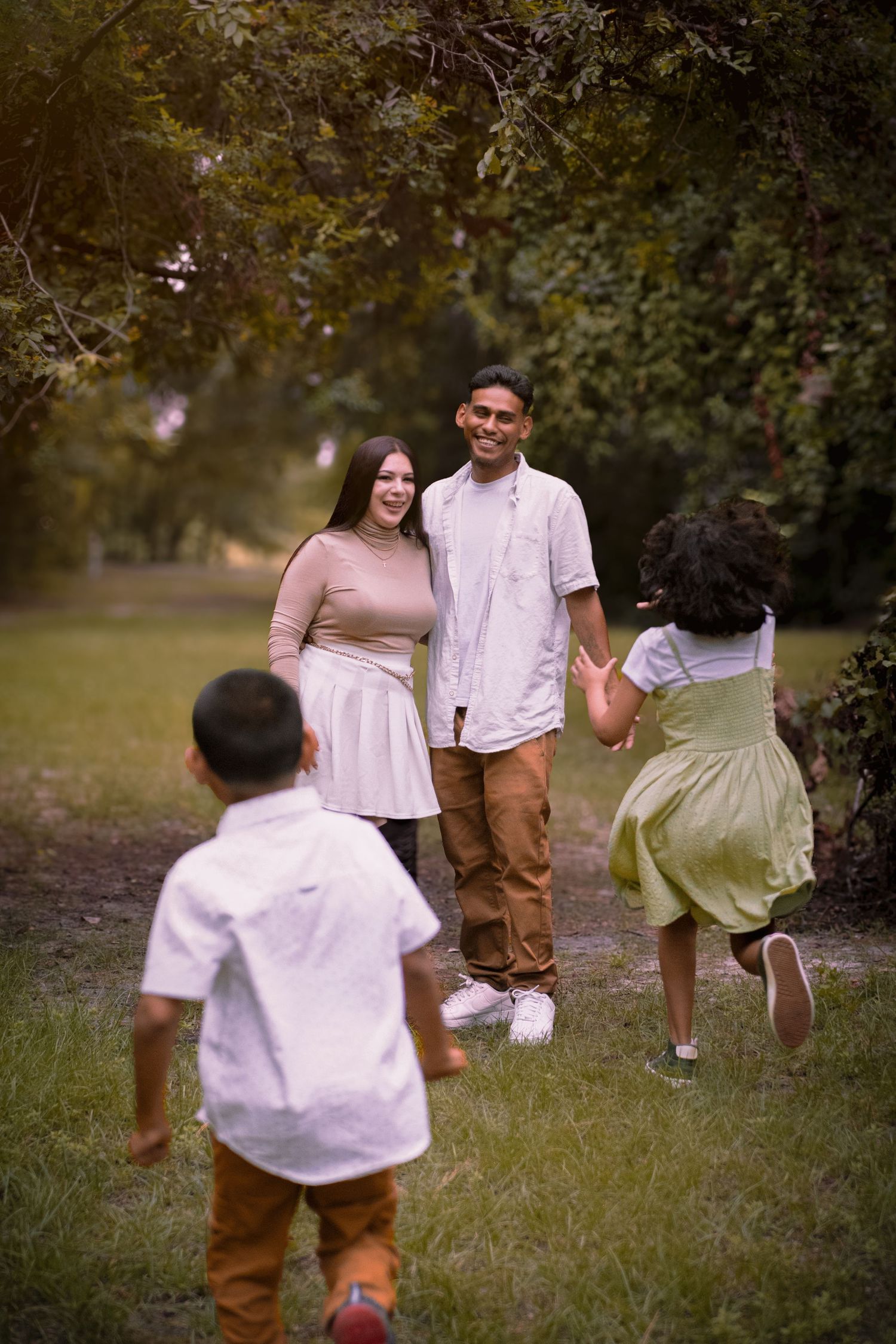 A family enjoys a playful moment together in a park setting.