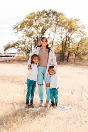 Aunt stands with her two nieces during an outdoor family session in Kearney, NE.