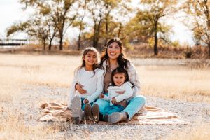Aunt and two nieces sit together on gold blanket by Central Nebraska family photographer.
