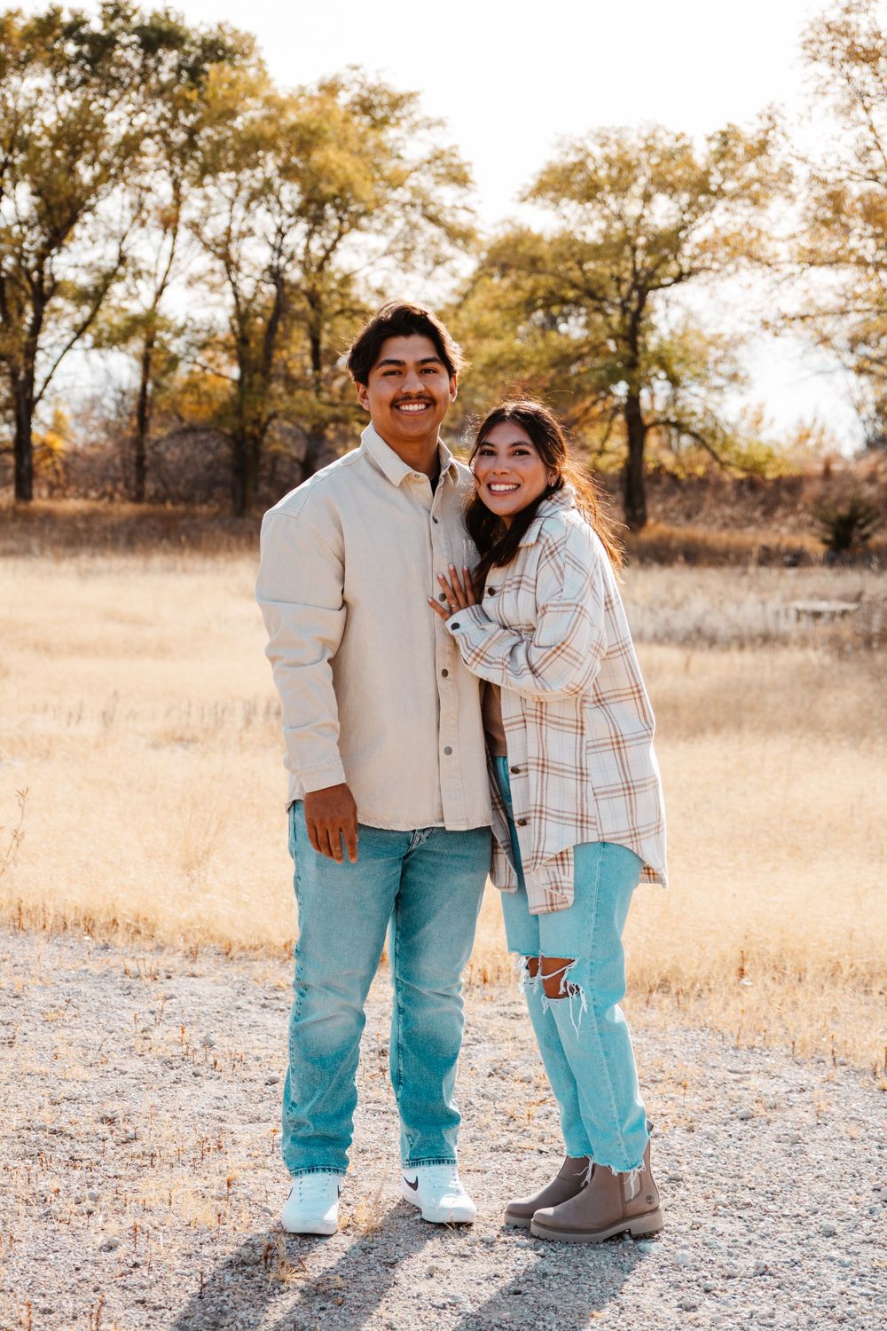 Male and female couple stand in an embrace outside during a natural light family photography session in Kearney, Nebraska.
