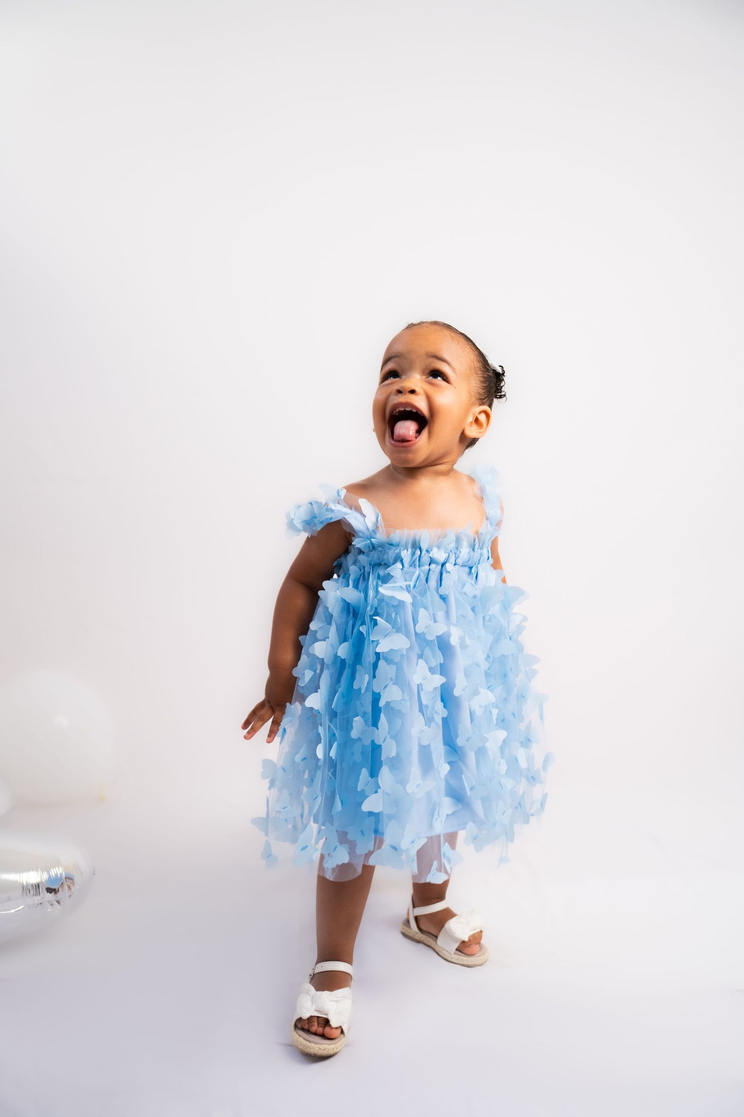 Light blue tulle dress with butterfly details photographed against white background.