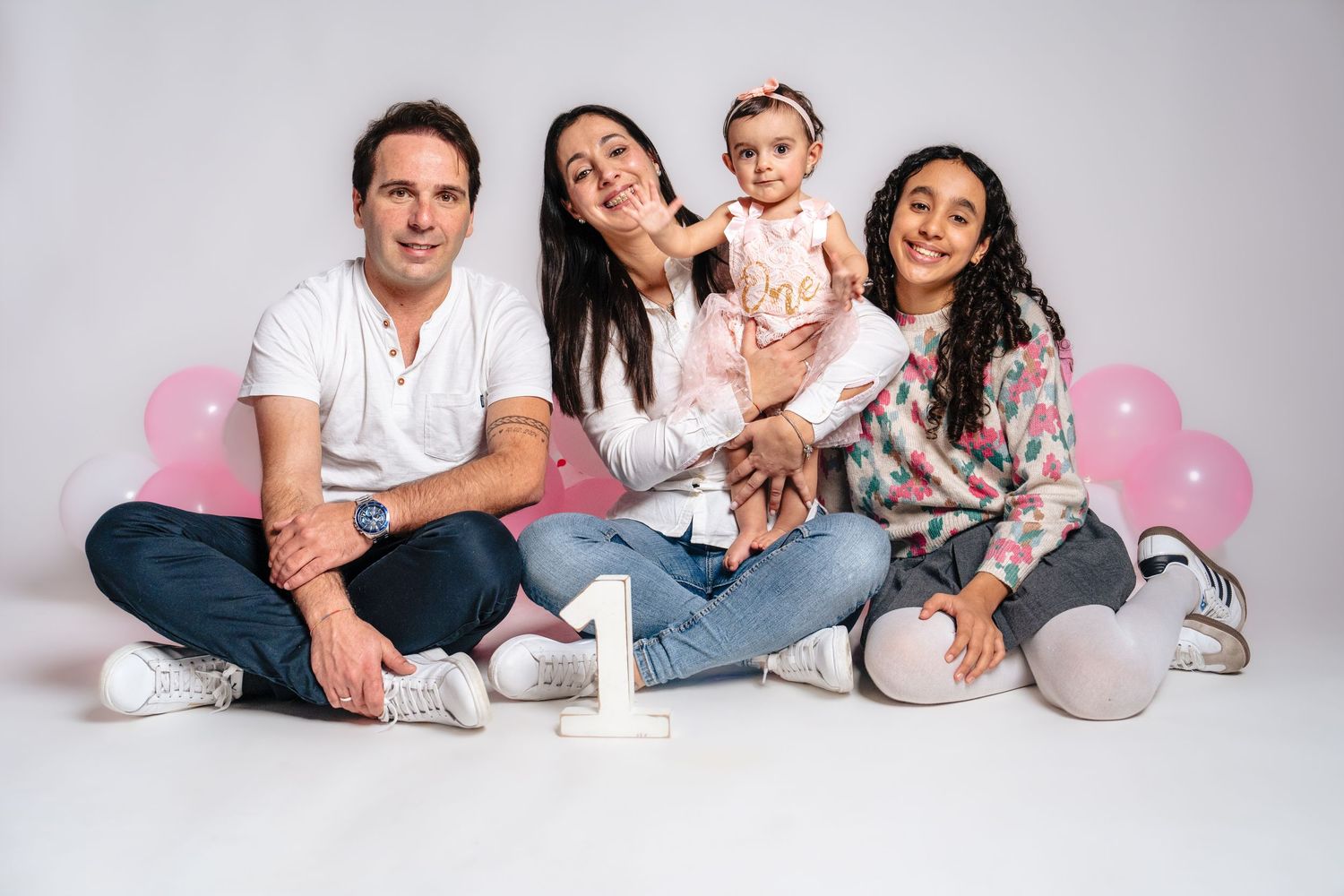 Family photo session setup with white backdrop and casual coordinated outfits.