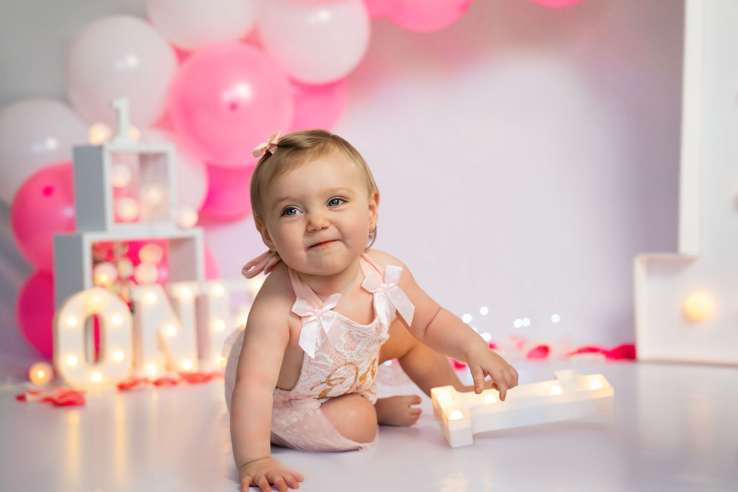 Pink balloon decorations with butterfly accents create a dreamy birthday party atmosphere.