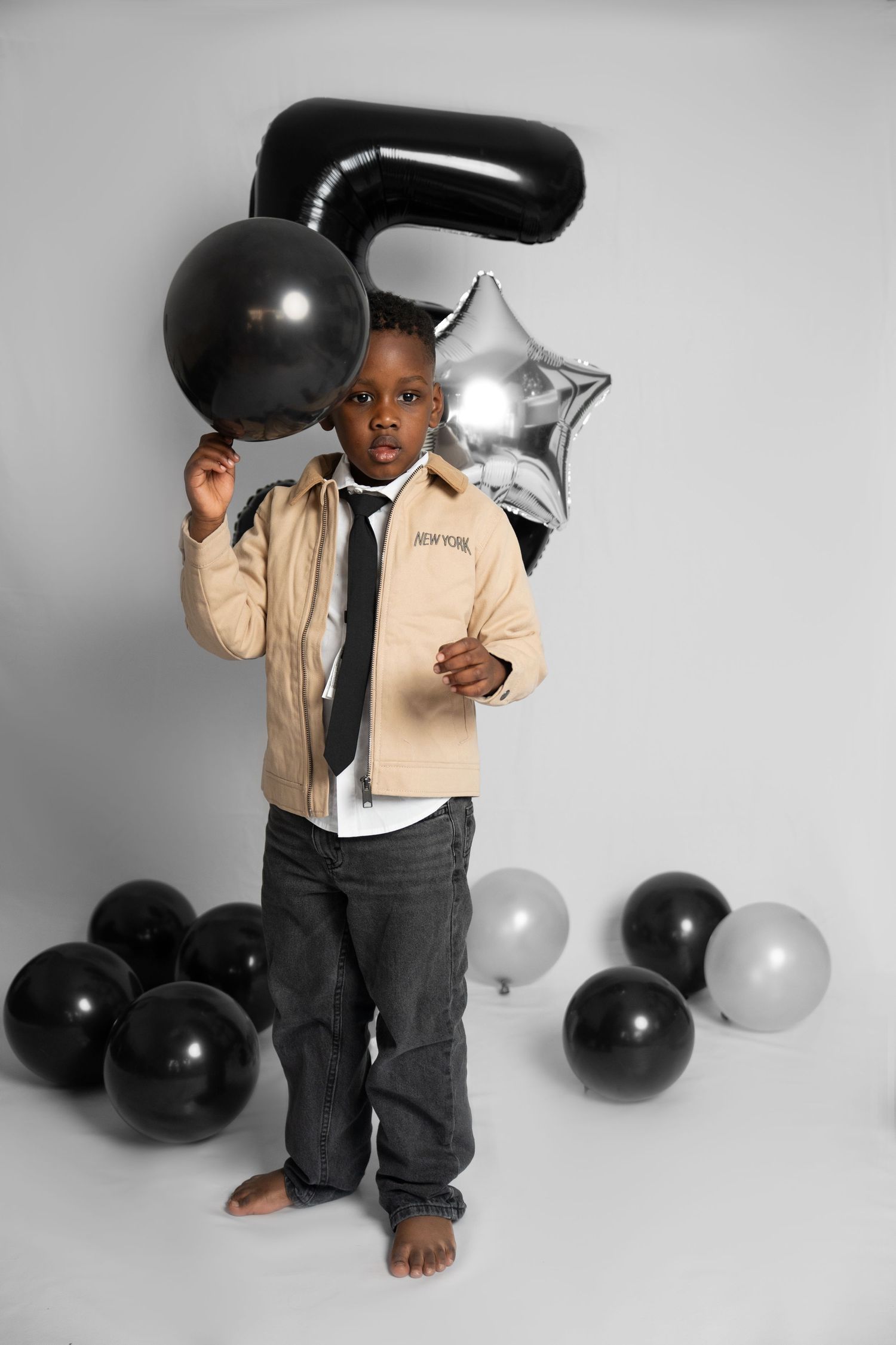 Monochrome birthday setup featuring black and silver balloons with number 5 decoration.