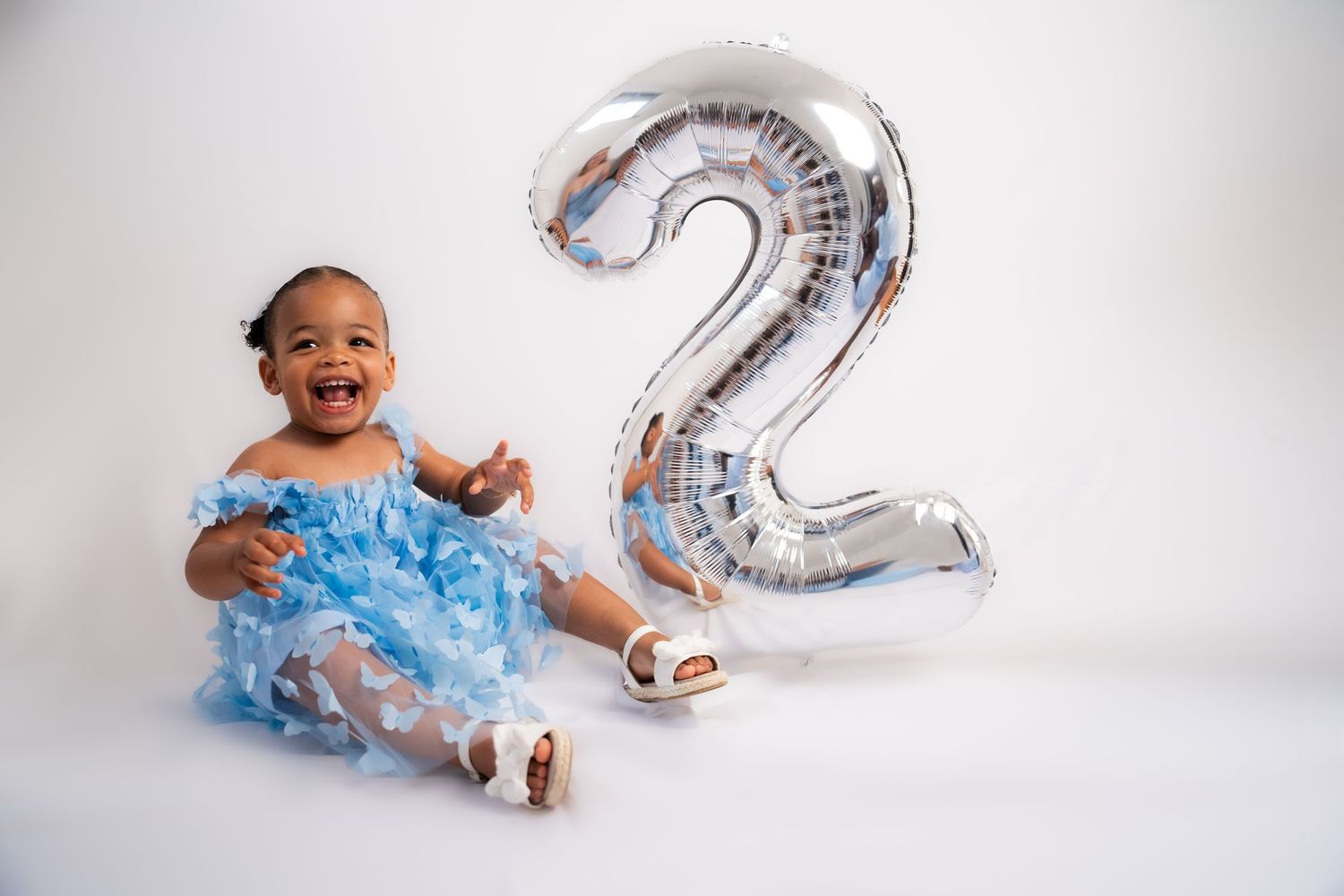 Silver number 2 balloon decoration with light blue tulle dress for birthday photoshoot.