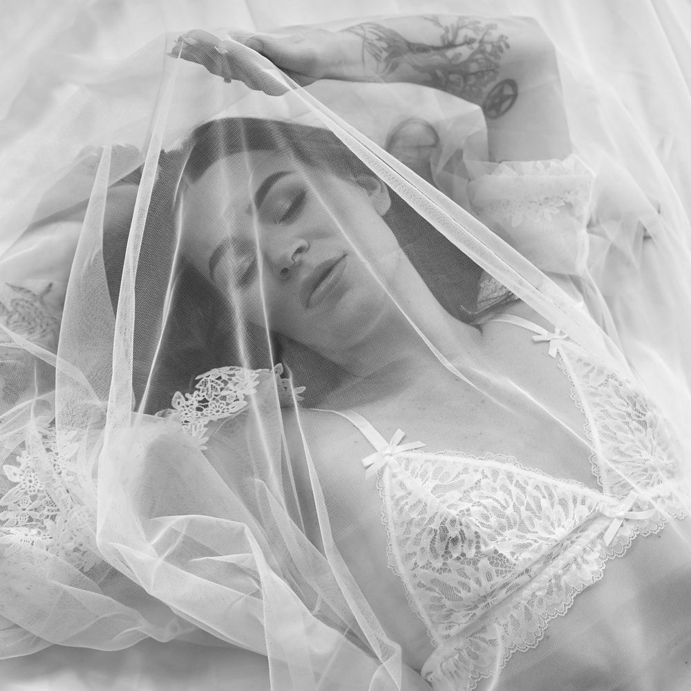 Ethereal boudoir photos with delicate lace veil creating soft dreamy effect.