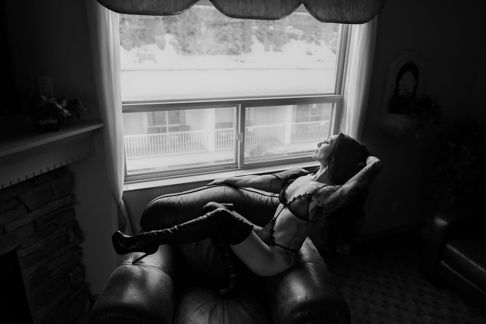 Black and white artistic portrait in dramatic lighting with shadows and contrast.