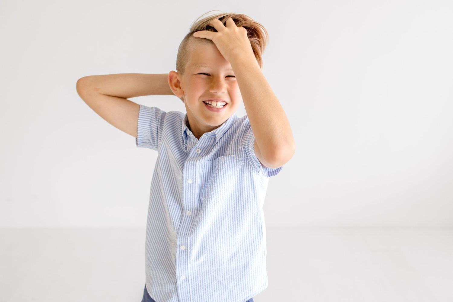Playful studio portraits showing animated expressions in light blue button-down shirt.