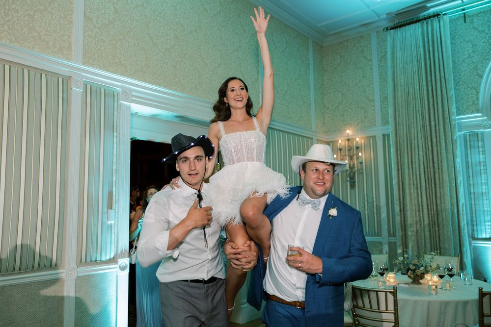 Couples dancing and celebrating at an elegant wedding reception with teal lighting.