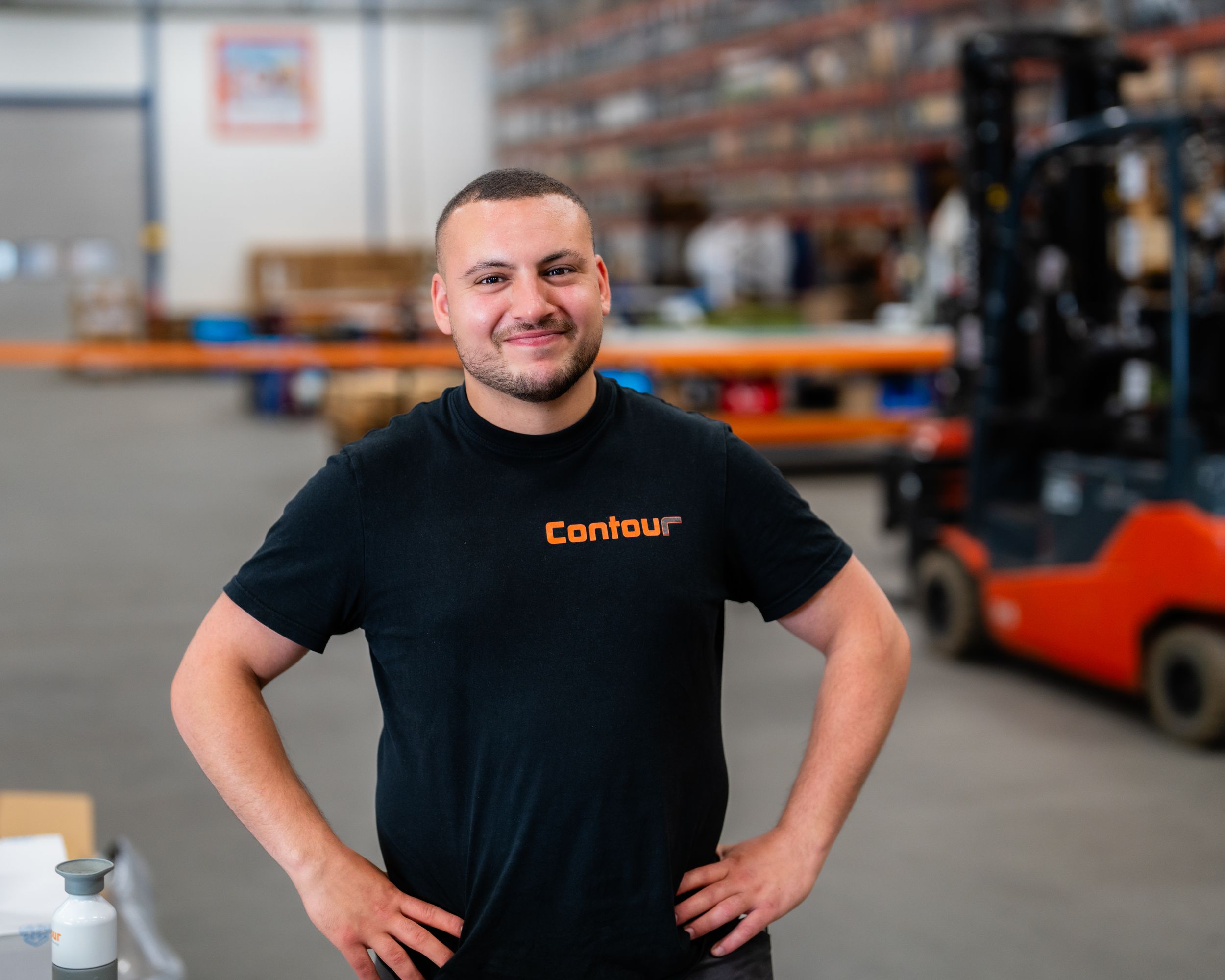 Professional staff members in black shirts pose confidently in a warehouse setting.