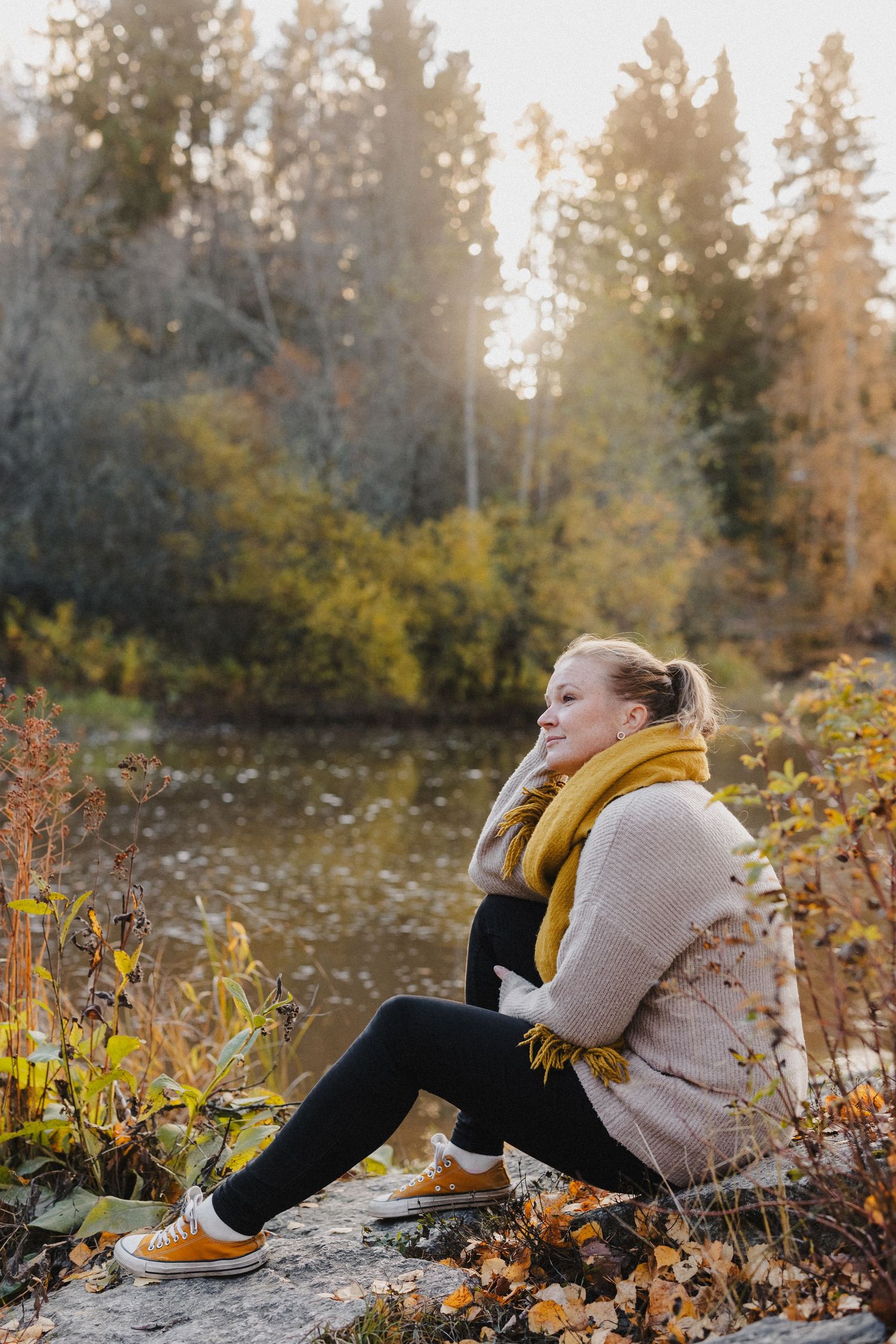 Valokuvaaja Annina Nygård syksyisessä miljöössä joen rannalla. Kuvan on ottanut Valokuvaaja Pinja Waris.