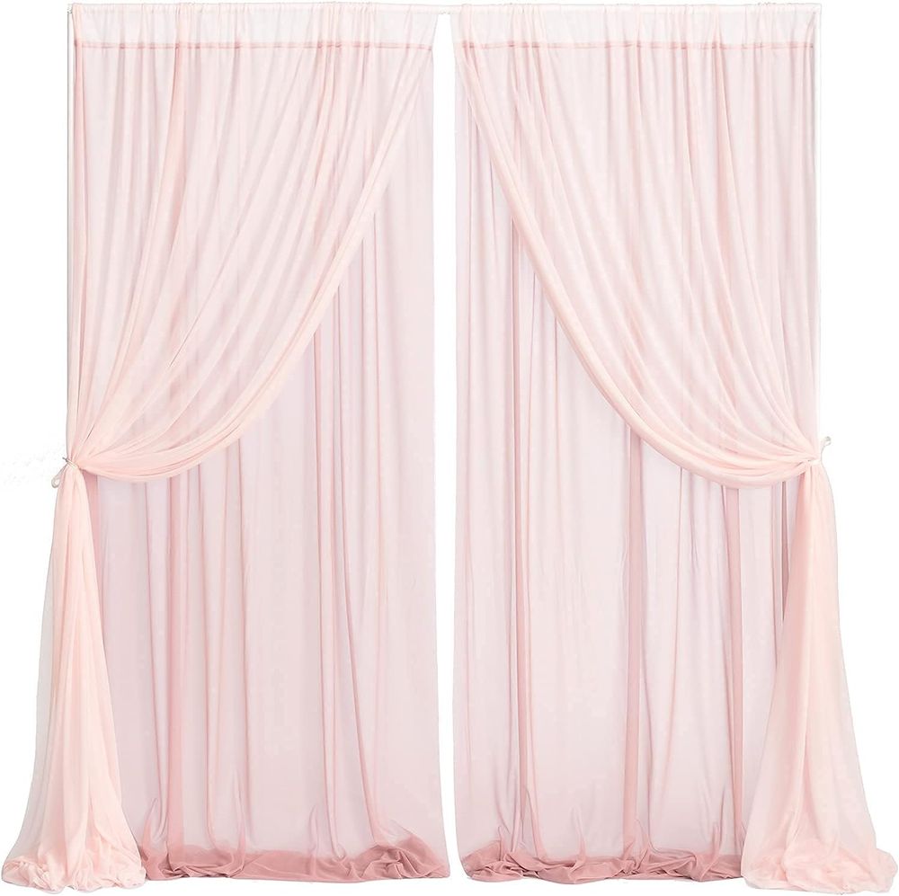 Elegant blush pink curtain panels with soft pleats and flowing fabric create a romantic window treatment display.
