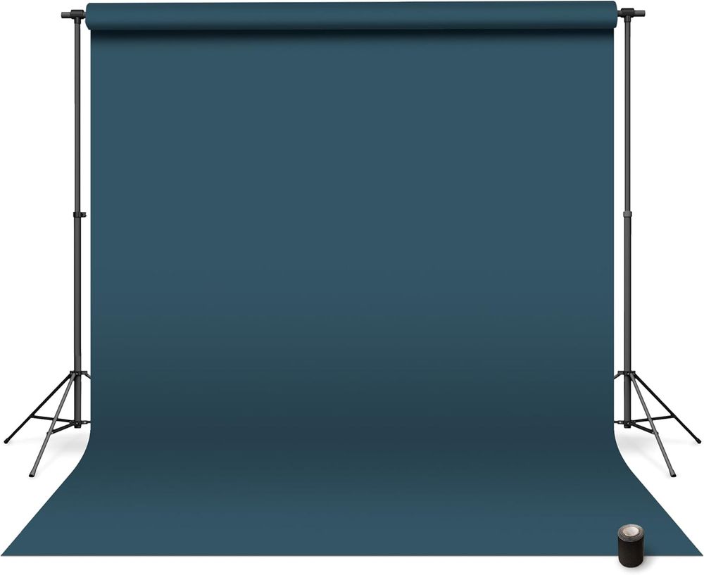 Photo studio backdrop setup showing four dark blue seamless paper backgrounds mounted on stands with lighting equipment.