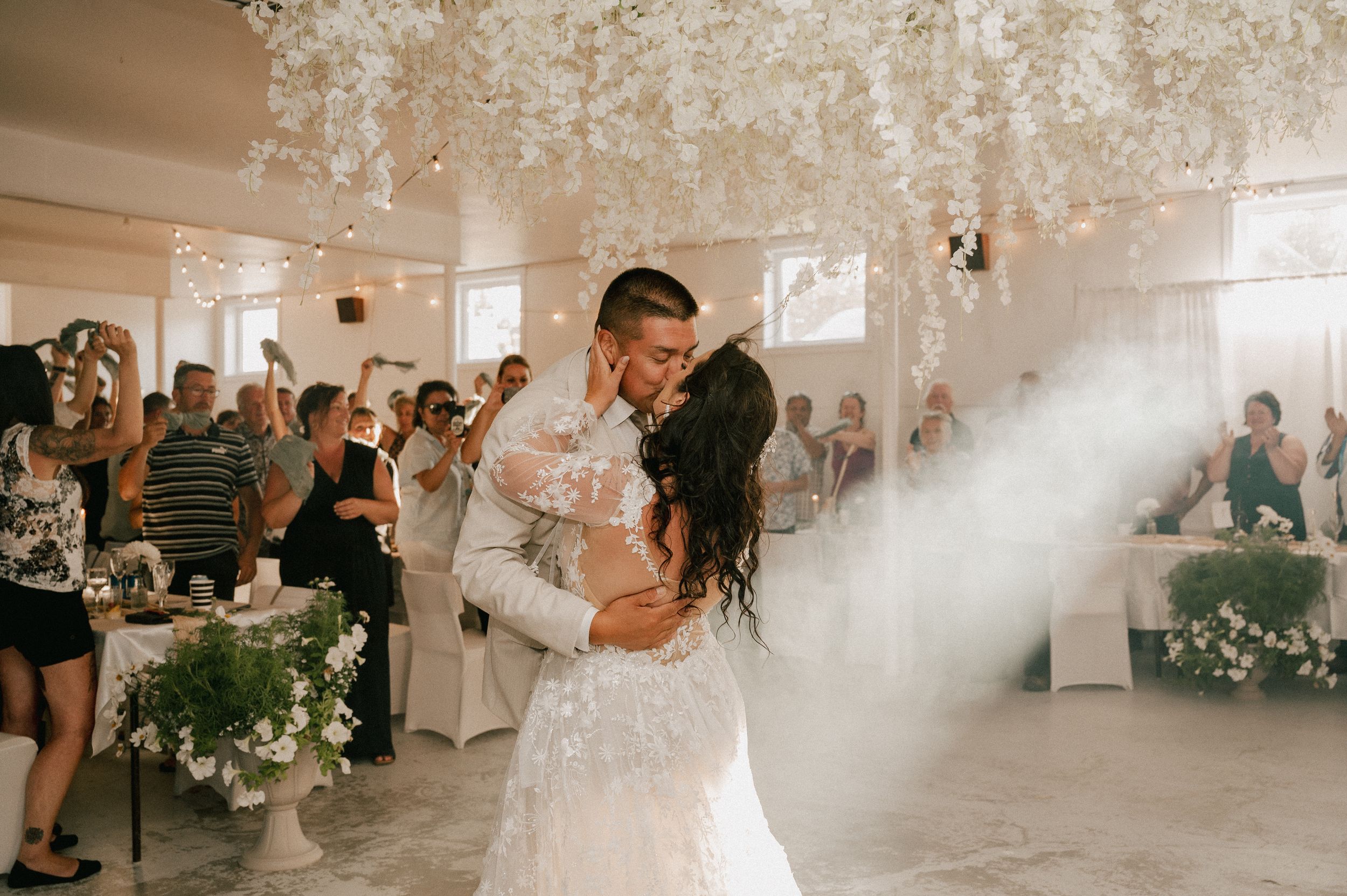 Collage of intimate wedding moments captured in an elegant white venue with crystal chandeliers and natural light.