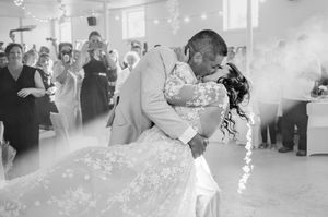 A romantic black and white photo of a couple sharing their first dance at their wedding reception.